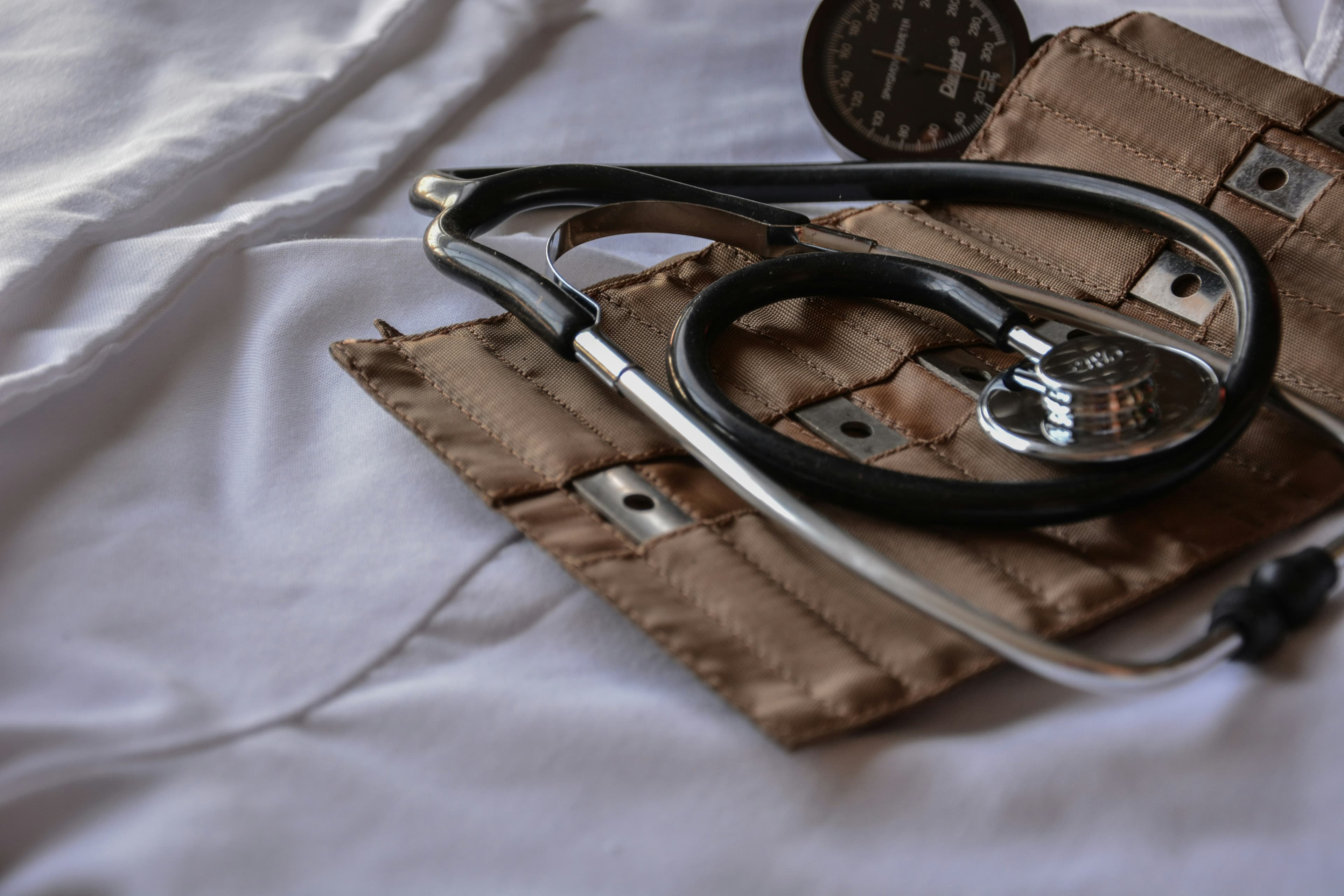 Estetoscopio y tensiómetro sobre un campo médico blanco